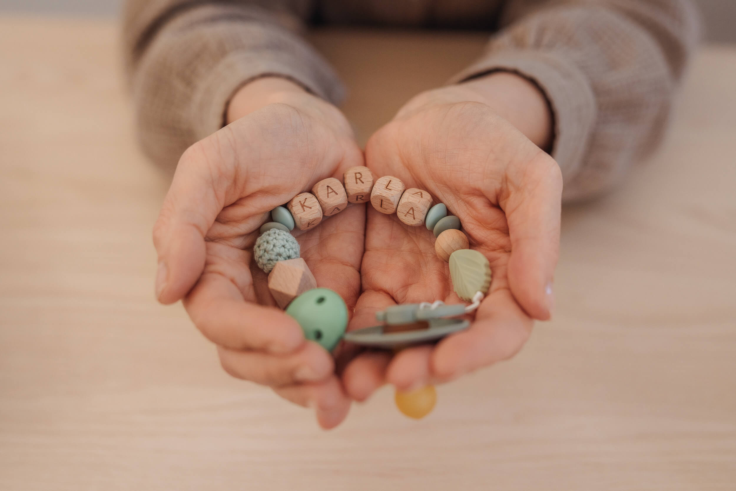 Schnullerkette liegt in Händen